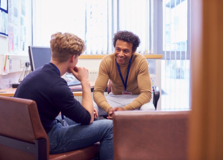 Two people seated in an office space having a one‑on‑one discussion